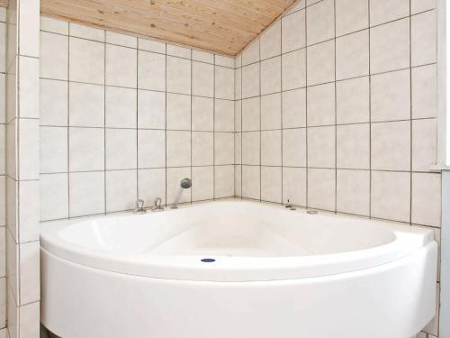 洛肯的住宿－6 person holiday home in L kken，瓷砖浴室设有白色浴缸。