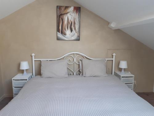 sypialnia z białym łóżkiem i obrazem na ścianie w obiekcie La Tulipe w mieście Durbuy