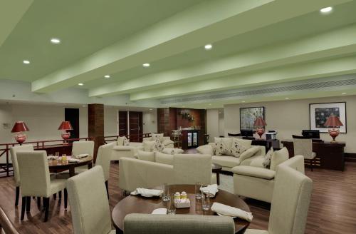 a living room with couches and chairs and tables at Royalton Hyderabad Abids in Hyderabad