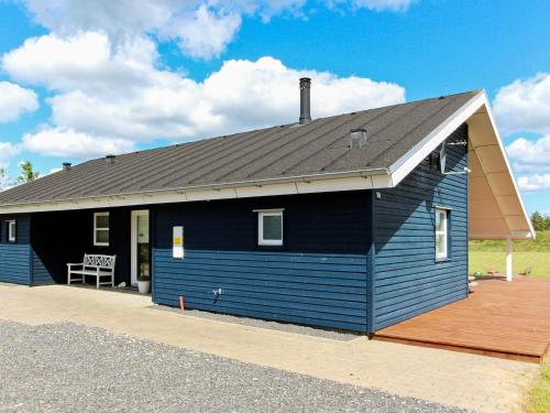 una casa azul con techo negro en 6 person holiday home in Brovst, en Brovst