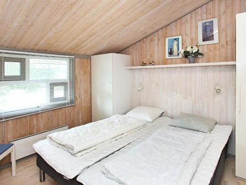 SkramにあるThree-Bedroom Holiday home in Ålbæk 20の木製の壁にベッド2台が備わるベッドルーム1室