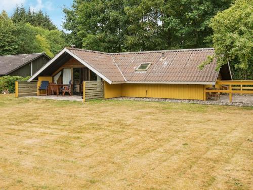 ein gelbes Haus mit einem Hof davor in der Unterkunft 6 person holiday home in Toftlund in Arrild