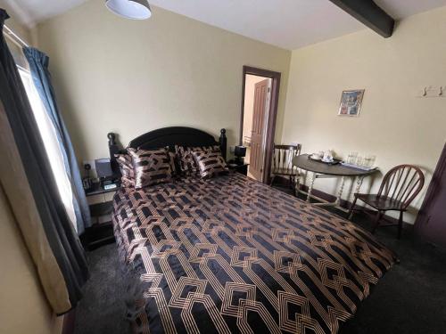 a bedroom with a large bed with a table and a tableablish at THE KINGS ARMS INN in Stratton