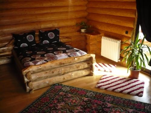 una camera con un letto in una baita di tronchi di Cabana Vultur a Vatra Dornei