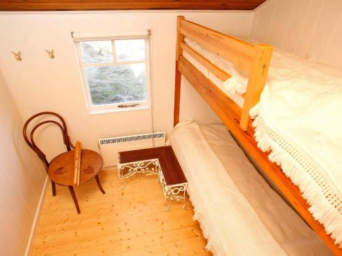ロッケンにあるTwo-Bedroom Holiday home in Løkken 12のベッドルーム1室(二段ベッド1組、椅子、窓付)