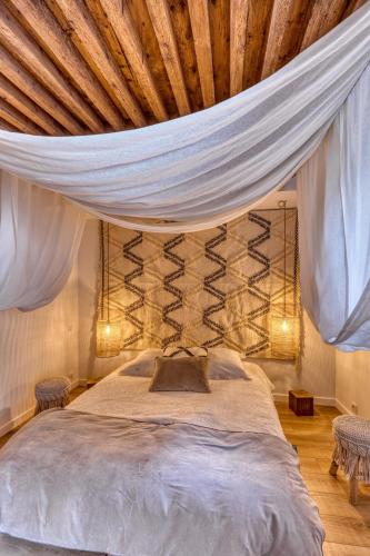 - une chambre avec un lit à baldaquin et 2 chaises dans l'établissement Un lieu unique Le Bohème, à Annecy