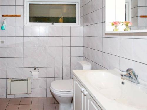 a white bathroom with a toilet and a sink at Three-Bedroom Holiday home in Hemmet 67 in Falen