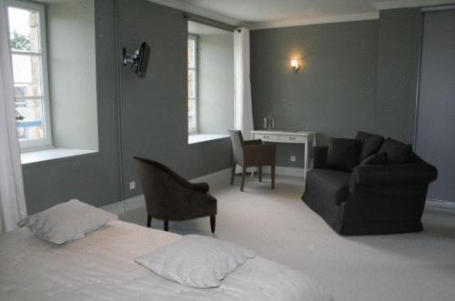 a bedroom with a bed and a couch and a desk at Demeures & Châteaux, La Ferme des Mares in Saint-Germain-sur-Ay
