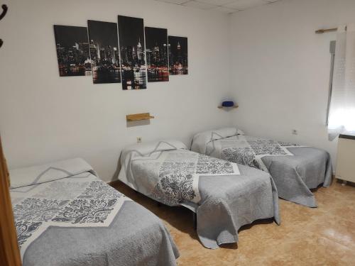 um quarto com três camas com cobertores em CASA RURAL DOÑA LUCINDA em Albacete