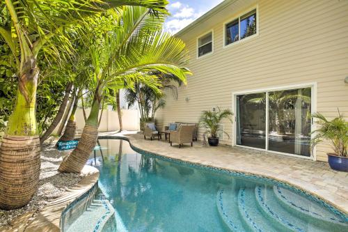 a swimming pool with palm trees next to a house at Indian Rocks Beach Oasis - 2 Blocks to Beach! in Clearwater Beach