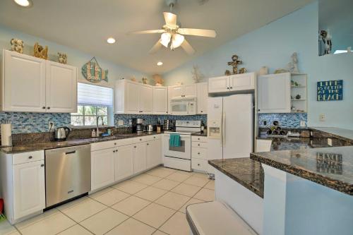 a kitchen with white cabinets and a ceiling fan at Indian Rocks Beach Oasis - 2 Blocks to Beach! in Clearwater Beach