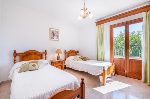 a bedroom with two beds and a window at Can Nina in Campanet