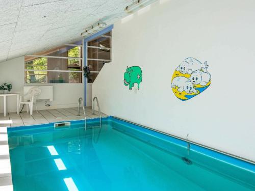 an indoor swimming pool with a blue pool at 12 person holiday home in Glesborg in Fjellerup Strand