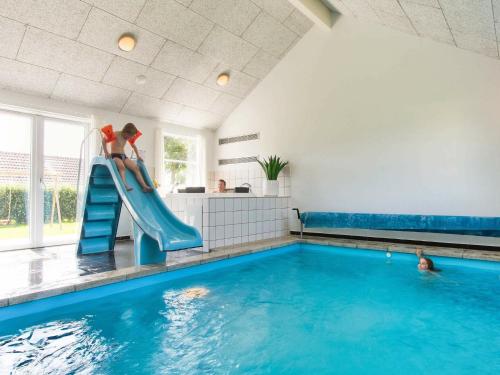 a woman on a slide in a swimming pool at 16 person holiday home in Bagenkop in Bagenkop