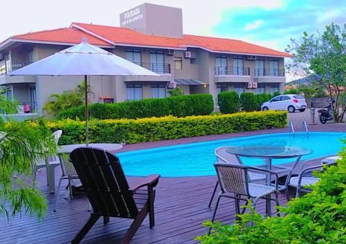a patio with a table and chairs next to a pool at Pousada Porto do Arvoredo in Florianópolis