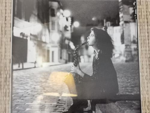 a woman sitting on a bench playing a saxophone at Logis Hotel Restaurant LA BARGUILLERE in Saint-Pierre-de-Rivière