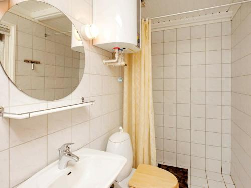 a bathroom with a sink and a toilet and a mirror at 6 person holiday home in Læsø-By Traum in Læsø
