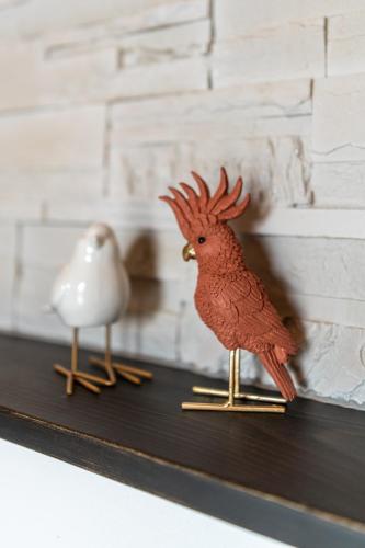 a toy bird and a figurine of a red bird on a shelf at San Miniato - Terrazza panoramica in centro storico in San Miniato