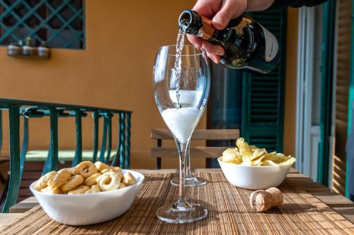 a person pouring wine into a wine glass on a table at San Miniato - Terrazza panoramica in centro storico in San Miniato