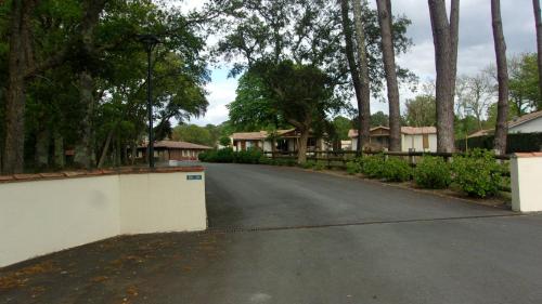Une rue vide avec une clôture et quelques maisons dans l'établissement chalet avec piscine, à Azur