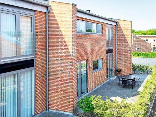 a brick building with a patio and a table at 8 person holiday home in Hemmet in Hemmet