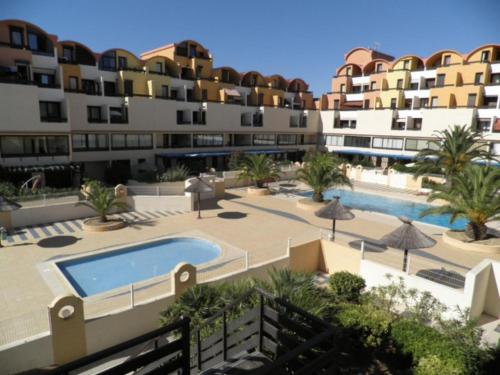 une vue d'un complexe avec piscine et bâtiments dans l'établissement La Brigantine, à Gruissan