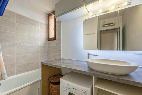 une salle de bain avec un lavabo et un miroir dans l'établissement La Brigantine, à Gruissan