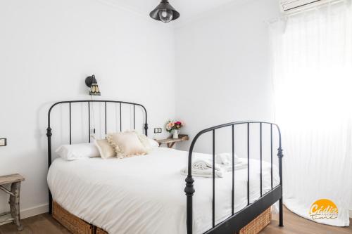 a bedroom with a black bed with white sheets and pillows at La Bella Escondida by Cadiz Time in Cádiz