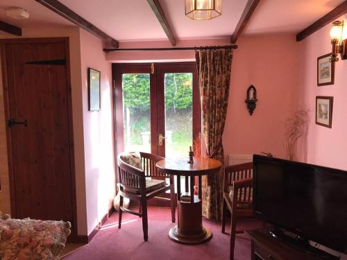 uma sala de estar com uma mesa e uma janela em Cosy Cottage for Ecotourism lovers near Corwen em Corwen