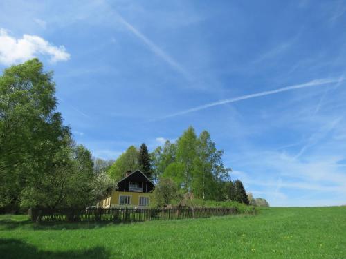 ein Haus mitten auf einem grünen Feld in der Unterkunft An eight person holiday home on a 1600 hectare estate in Tachov