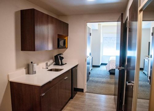 a kitchen with a counter and a sink and a room at Holiday Inn & Suites - Savannah Airport - Pooler by IHG in Savannah