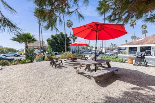 a red umbrella sitting on top of a wooden table at The Patriots Boutique Motel in San Clemente