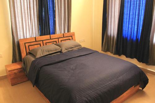 a bedroom with a bed with a blue comforter at Karjat Villa (3 BHK) With Garden Amidst Nature in Karjat