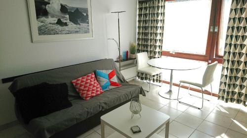a living room with a couch and a table at Studio Algarve in Middelkerke