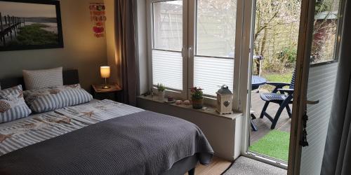 um quarto com uma cama e uma porta para um pátio em FeWo Auszeit em Harrislee