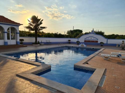 a large swimming pool in a courtyard with a building at Sol Poente in Évora