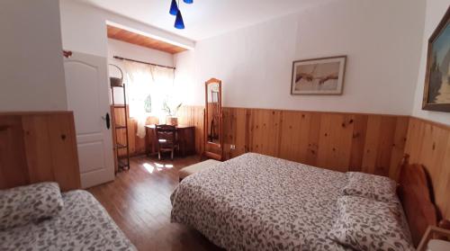 a bedroom with two beds and a table and a window at Barrancolaurel in Moya