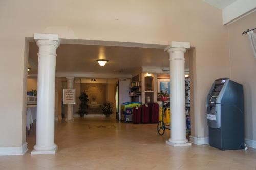 a hallway with columns and a blue machine in a building at America's Inn Houston in Houston