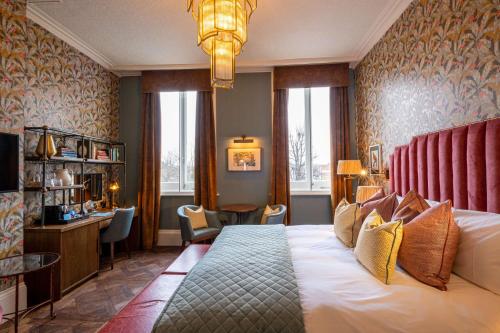 a hotel room with a large bed and a desk at The Park Hotel in Teddington