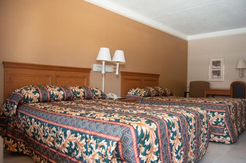 a hotel room with two beds and two lamps at America's Inn Houston in Houston