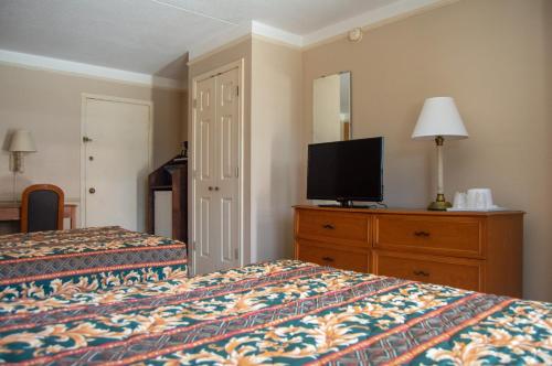 ein Hotelzimmer mit 2 Betten und einem Flachbild-TV in der Unterkunft America's Inn Houston in Houston
