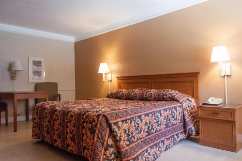 a hotel room with a bed and a desk at America's Inn Houston in Houston