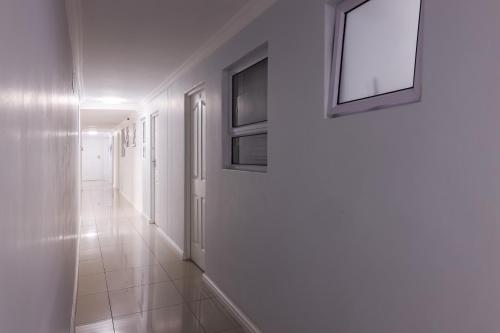 a hallway with white walls and pictures on the wall at Modern apartments at CZ KUBS in East London