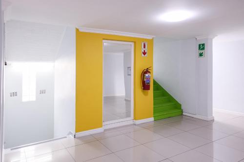 a hallway with a yellow door and a fire hydrant at Modern apartments at CZ KUBS in East London