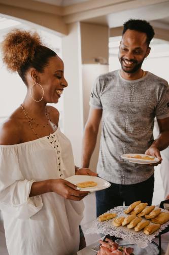 a man and a woman holding plates of food at La Pagerie - Tropical Garden Hotel in Les Trois-Îlets