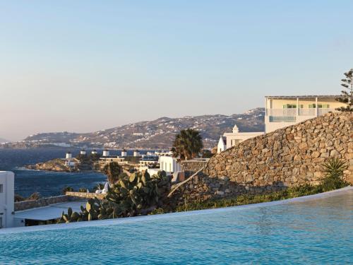 a swimming pool with a view of the ocean and buildings at Mykonos Earth Suites in Mýkonos City