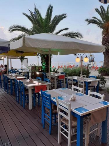 a row of tables and chairs with umbrellas on a deck at Hotel Zografos in Paralia Katerinis