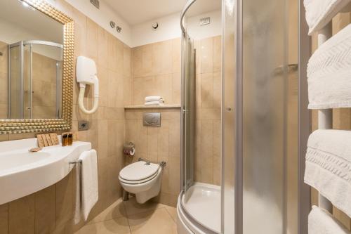 a bathroom with a toilet and a sink and a shower at Hotel Katja in Bibione