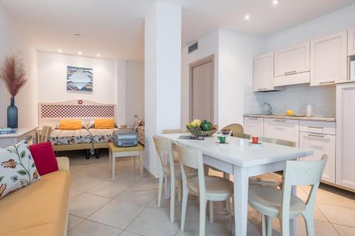 a kitchen and living room with a white table and chairs at Hotel Katja in Bibione