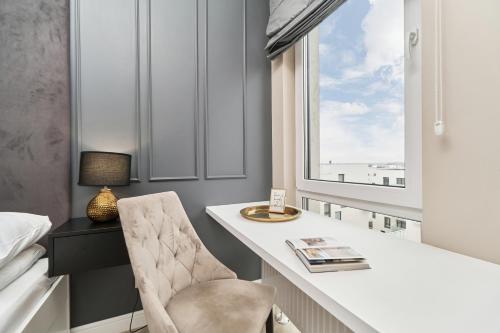 - une chambre avec un bureau, une chaise et une fenêtre dans l'établissement Apartments Wrocław Aleja Architektów by Renters, à Wrocław